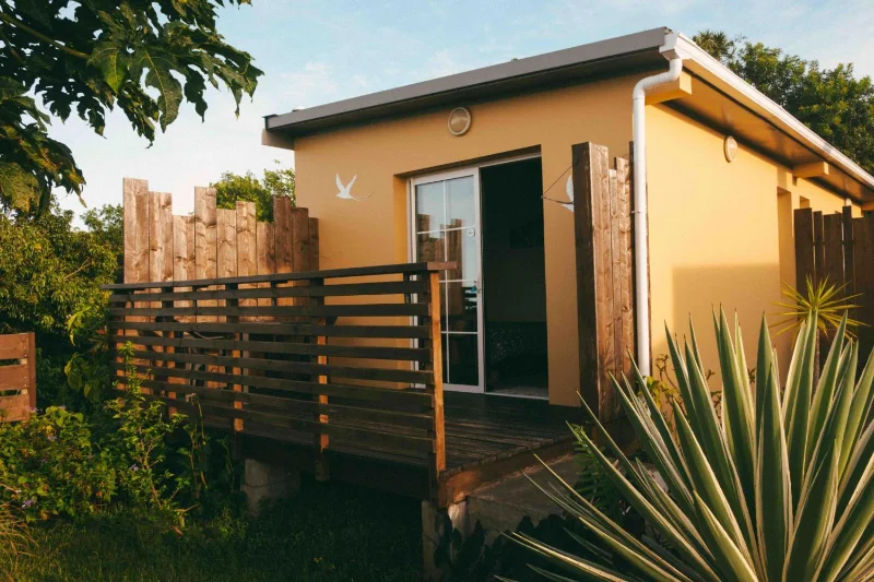 L'entrée d'une chambre de la Kazanou, sa terrasse en bois au milieu du jardin
