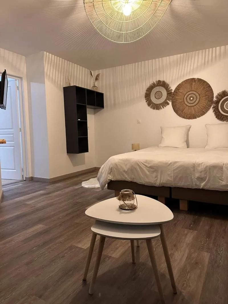 Une chambre de la Kazanou : le grand lit, les soleils de paille au mur et la table basse