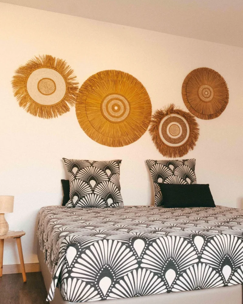 La chambre Passion : lit double, coussins à motifs éventails et soleils de paille tressée