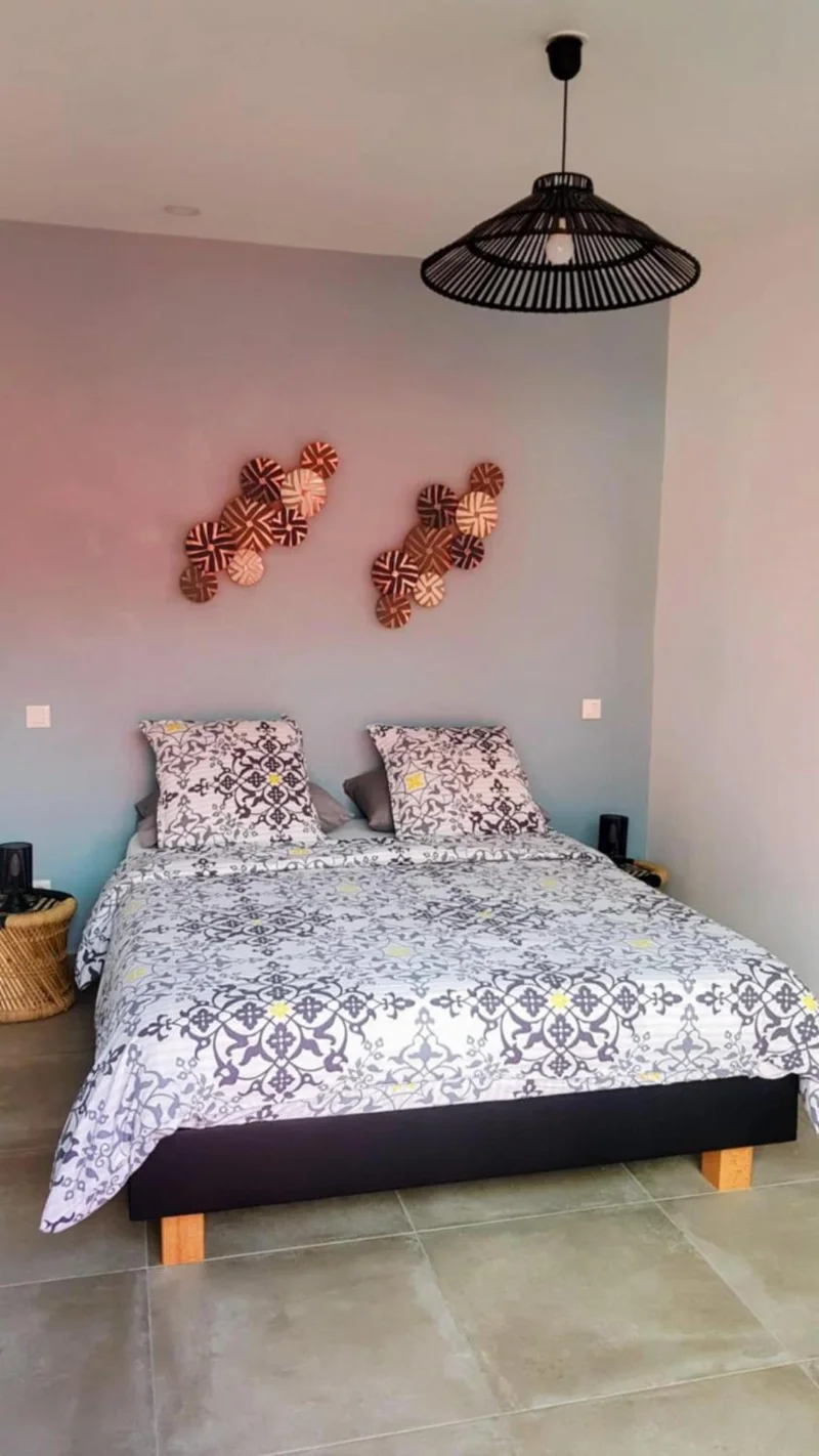 La chambre Margouillat : mur gris rosé, lit double et suspension noire