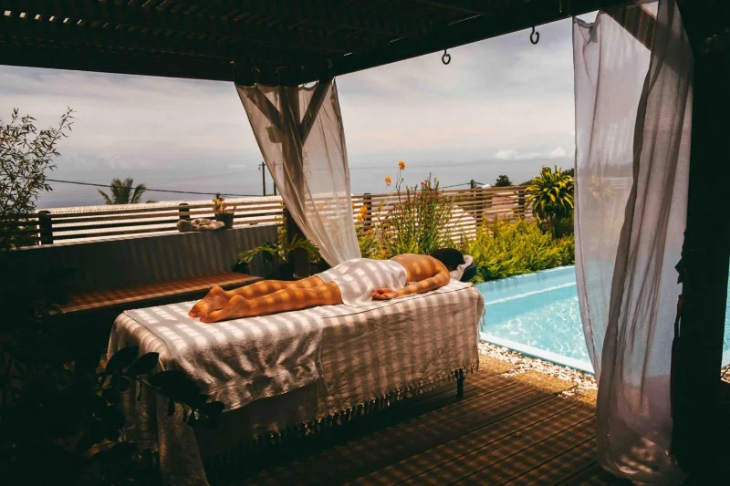 La table de massage installée sous la pergola, face à la piscine et à l'océan